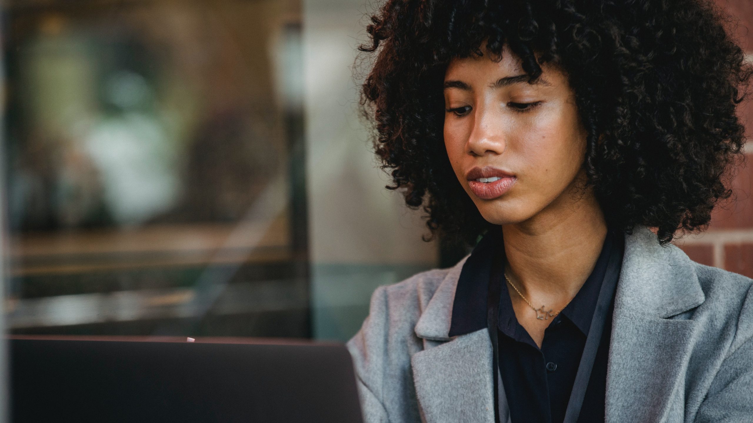 A Black woman working on her computer.