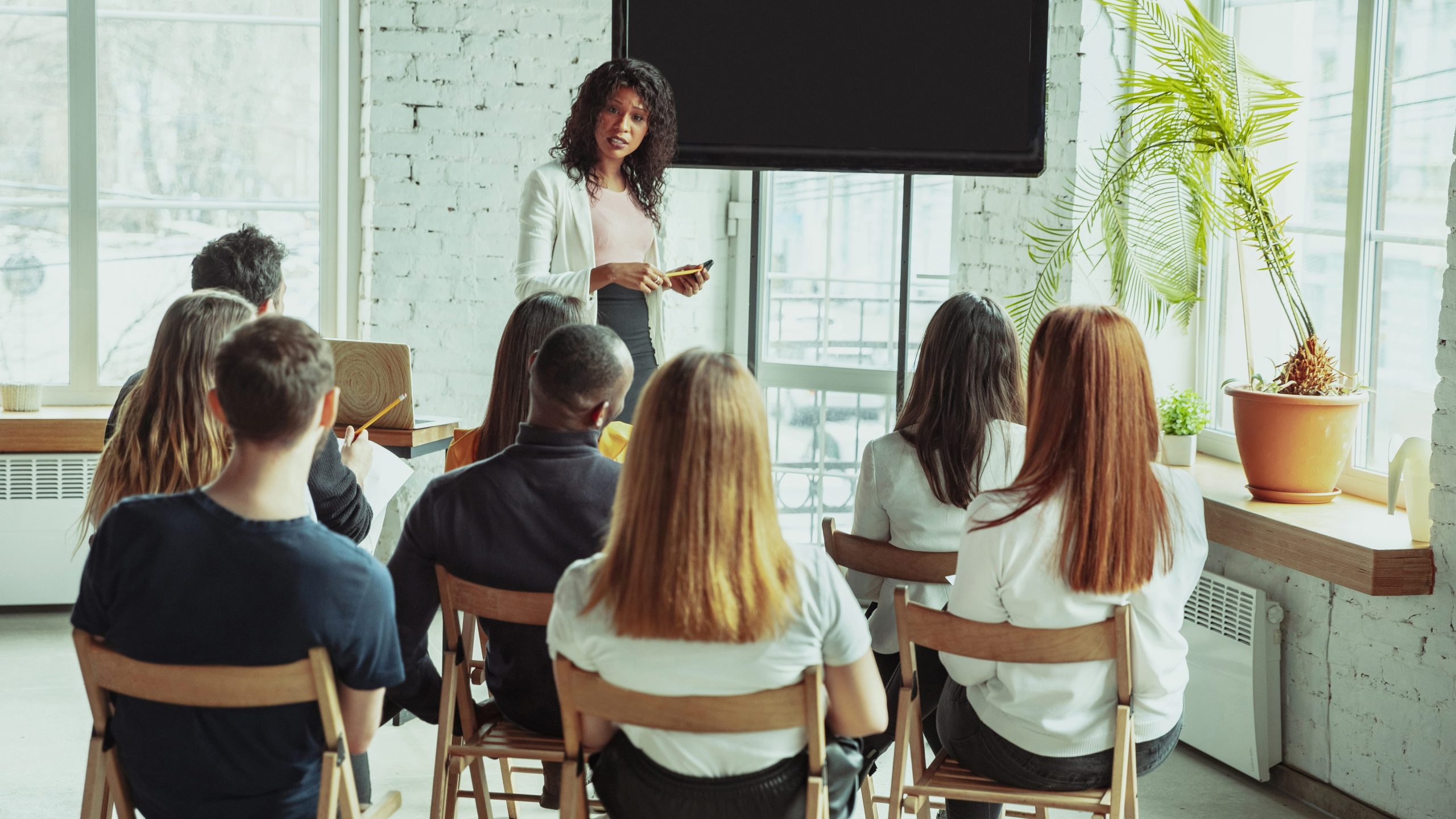 Female african-american speaker giving presentation in hall at university workshop