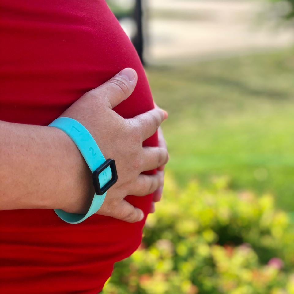 A pregnant woman wears a kick counting bracelet