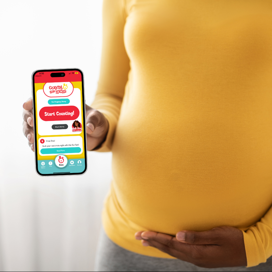 Pregnant Black woman holding a mobile phone with the Count the Kicks app on the screen