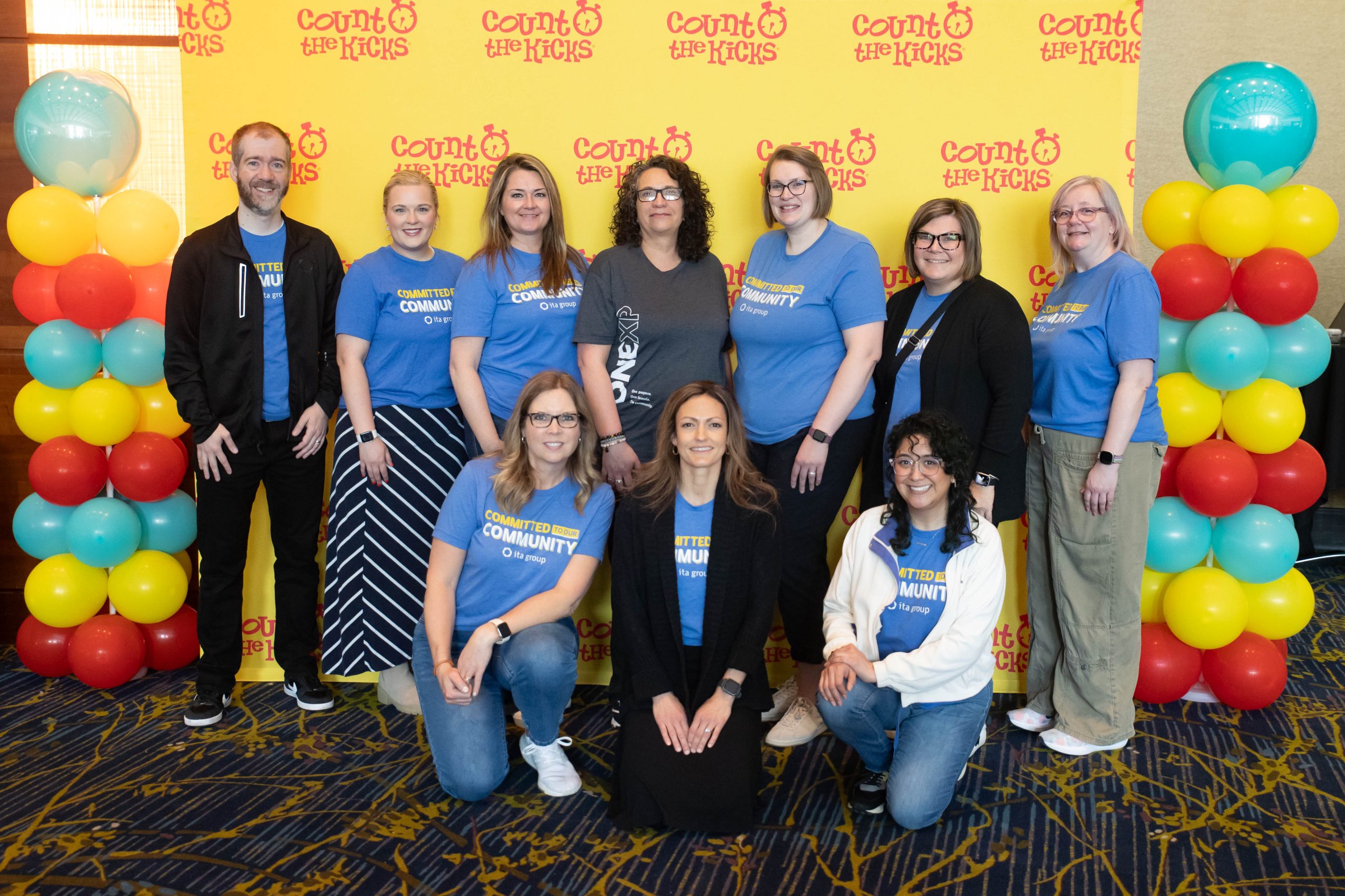 A group of ten people pose in front of a 